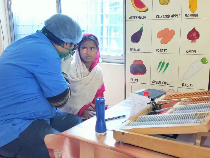 A child undergoing a vision screening as part of the Divine Child Health Program
